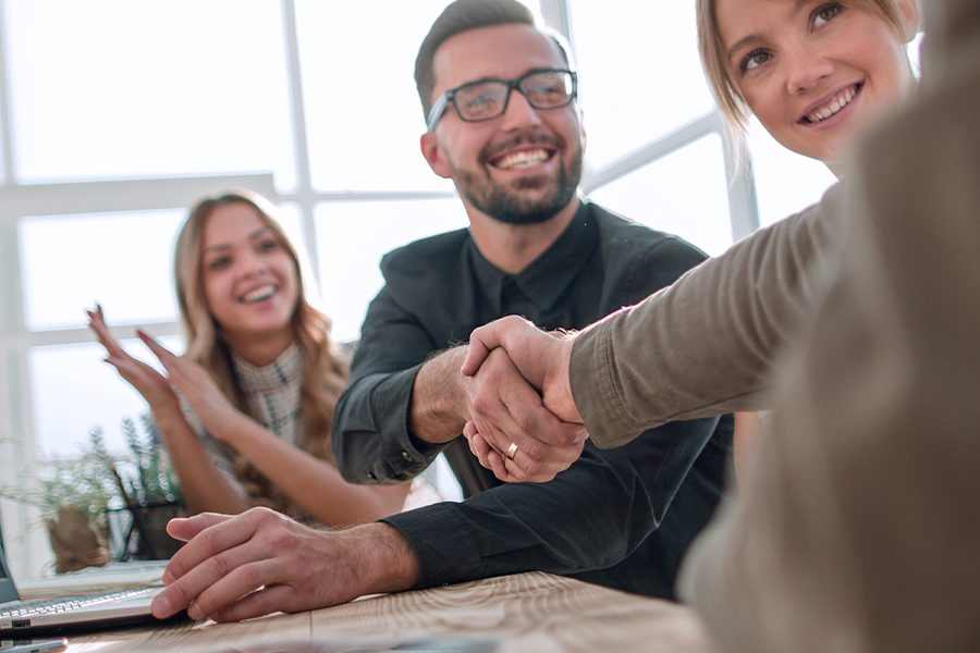 About Our Agency - Closeup of Business Associates Shaking Hands in a Meeting