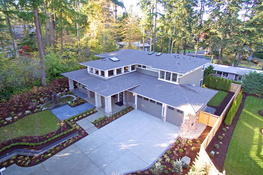 Contact - Aerial Closeup View of Modern Upscale Home in the Woods