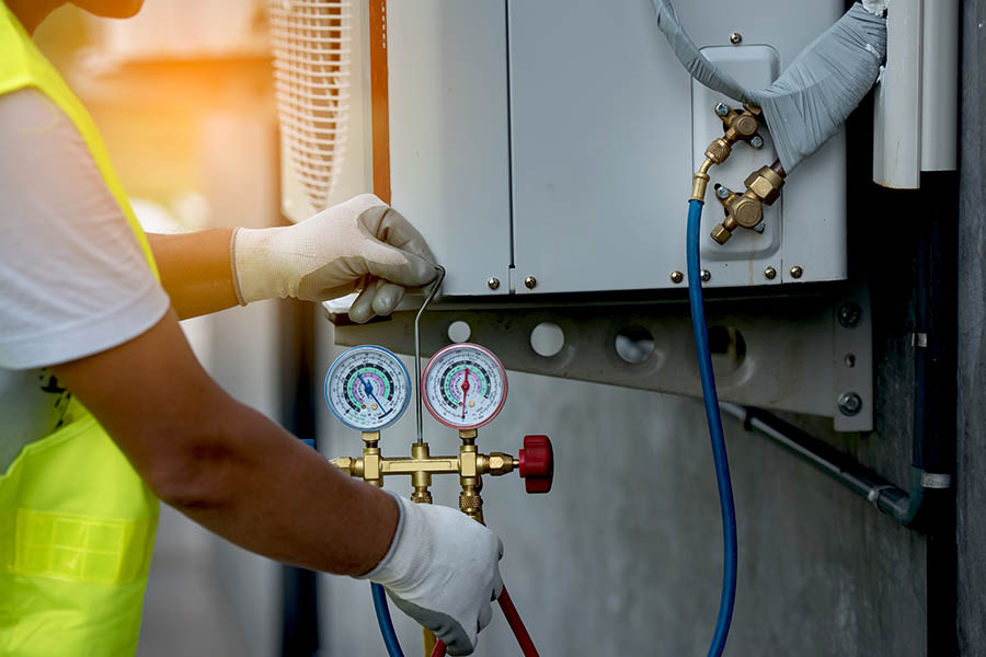 HVAC Contractor Insurance - Worker Fixing a Broken Air Conditioning Unit of a Business